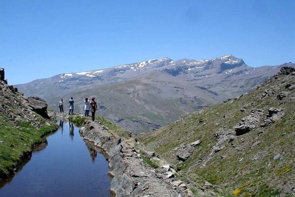Wasserbecken mit den verschneiten Gipfeln der Sierra Nevada im Hintergrund